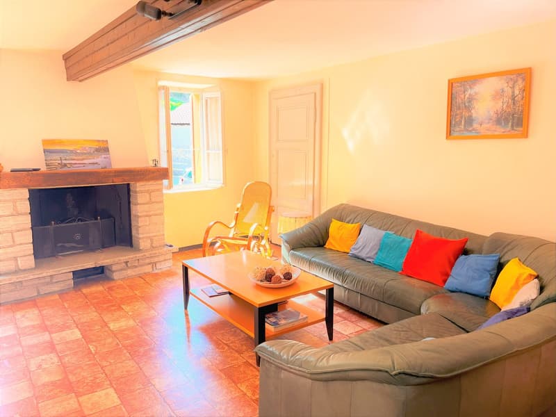 Fireplace, wooden coffee table, sofa, wooden rocking chair, carpet, picture frames