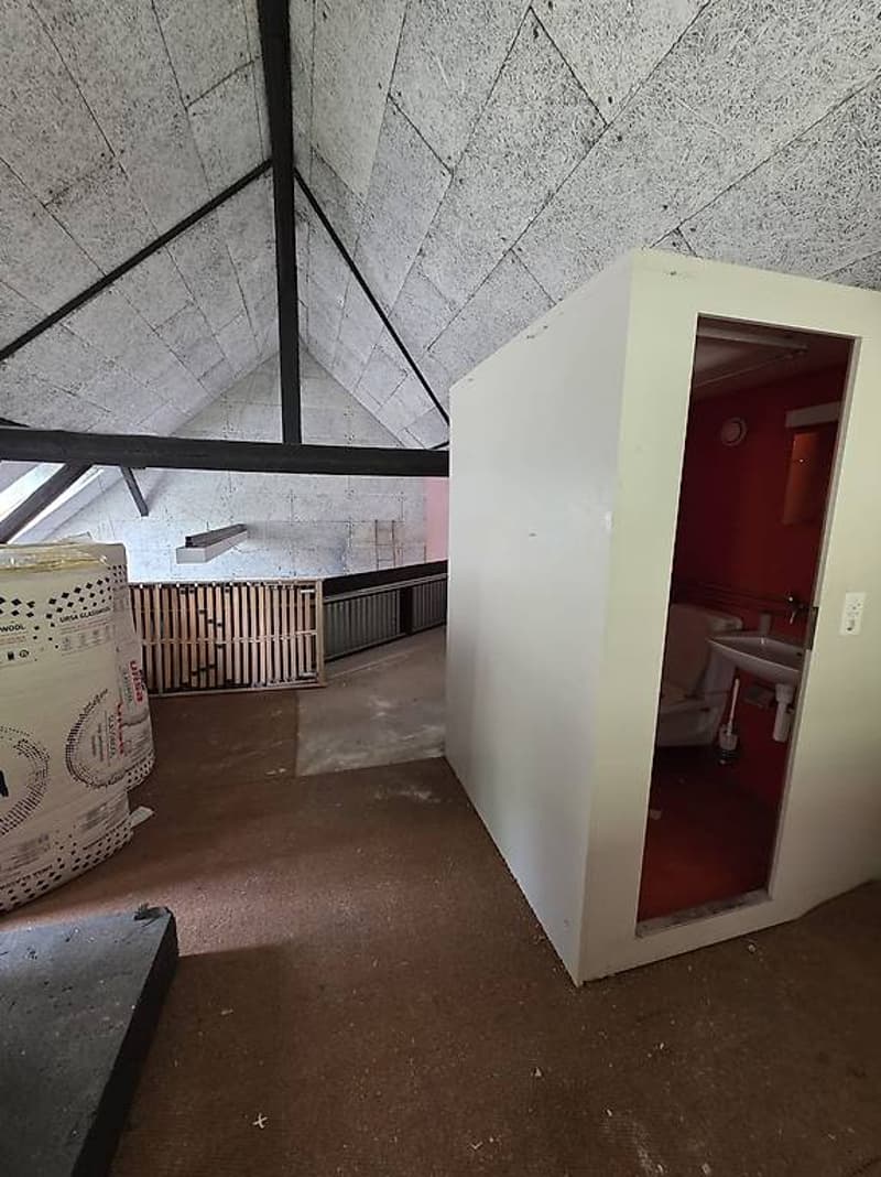 empty room, unfinished bathroom stall, storage boxes, metal beams, unfinished floors