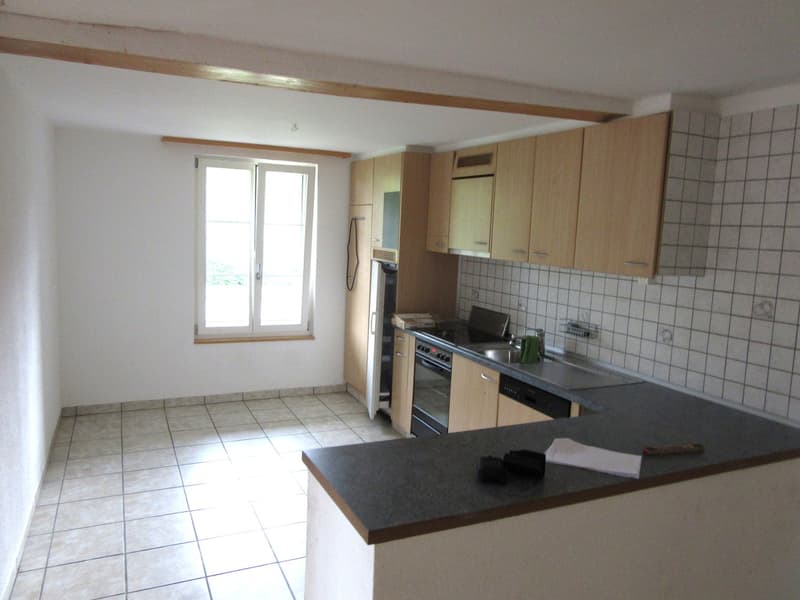 empty kitchen with tiled floor, wooden cabinets, black countertop, sink, oven, dishwasher, window