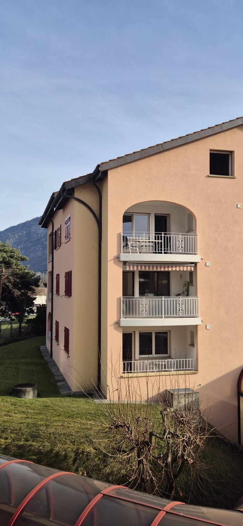 3-story building, beige color, red shutters, white railings, balcony