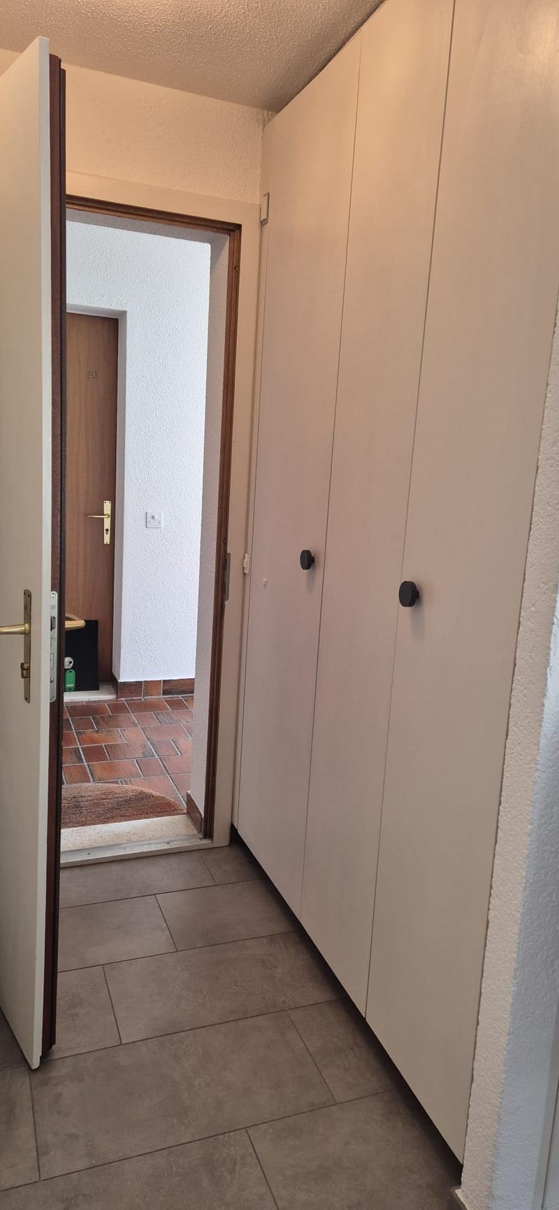 open door leading to hallway, large built-in wardrobes, tiled floor