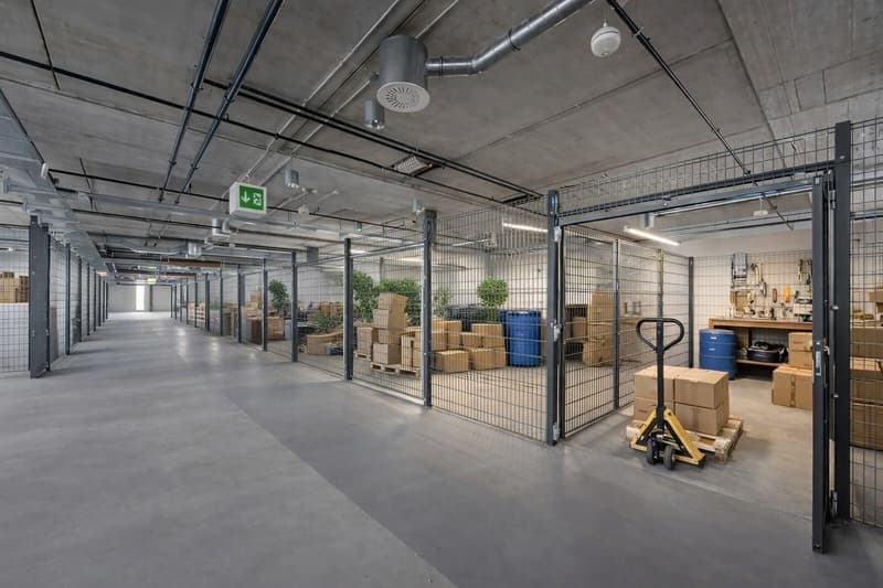 Warehouse with metal cages, storage boxes, and a forklift