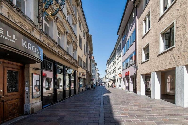 Brick facade buildings with stores on the ground floor, a cobblestone street