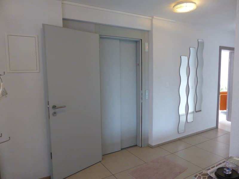 elevator access, white door, white and beige walls, tiled floor, hanging rack