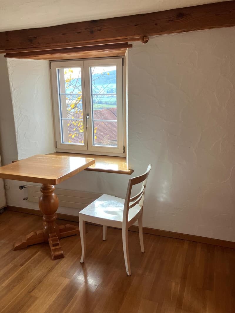room with wooden table, white chair, white wall, window, wooden floor