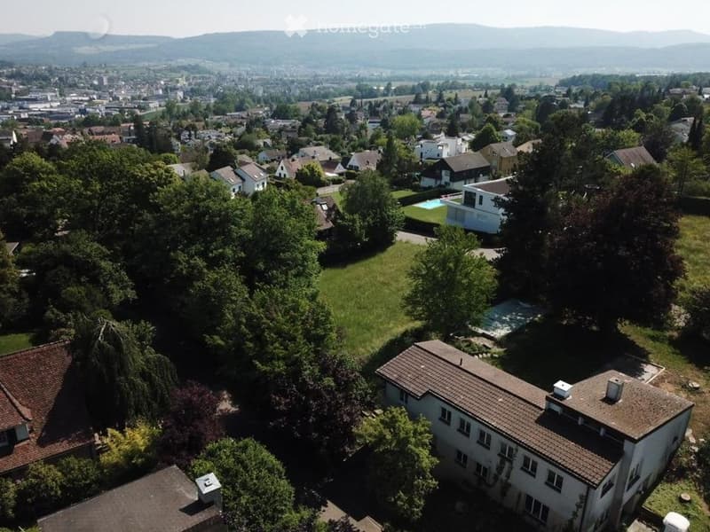 aerial view of houses, pool, trees, city, mountain