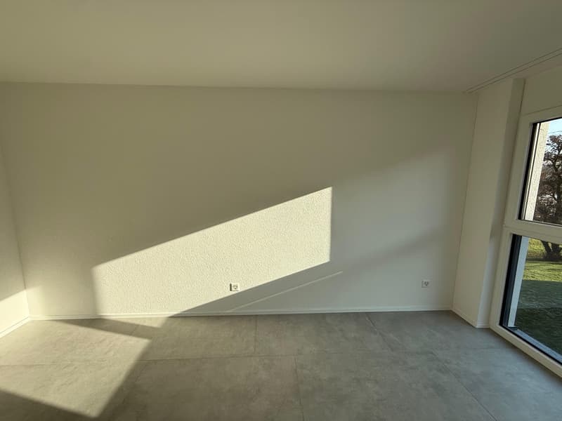 empty room, white walls, tiled floor, large window with view of grass
