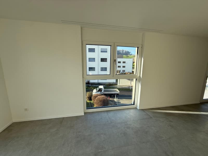empty room, large window, white walls, gray floor, power outlet