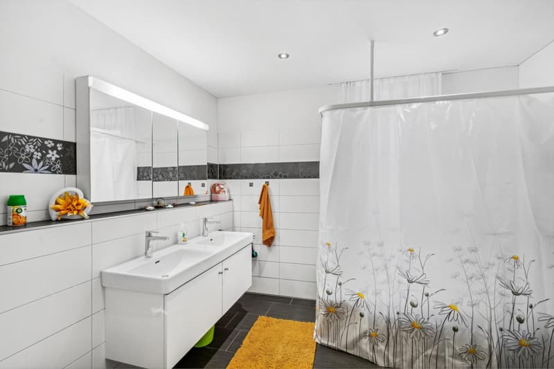 modern bathroom, white tiles, white sink, mirror, shower curtain, yellow rug