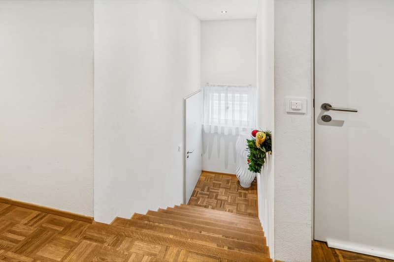 wooden floor, white walls, staircase, white door, white window with curtains