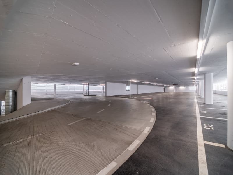 Empty, large, illuminated, and clean parking area.