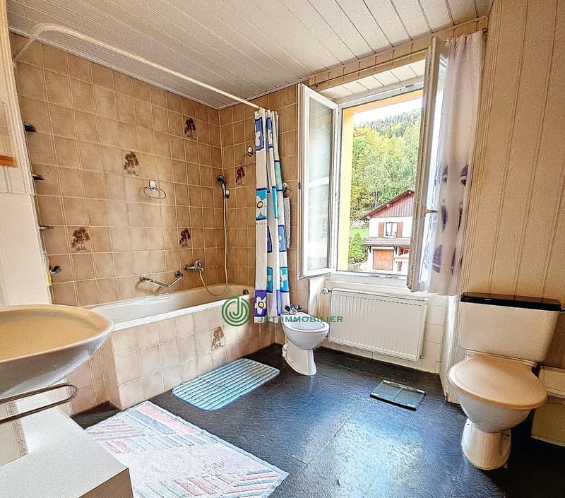 Bathroom with bathtub, toilet, sink, window with view, radiator, shower curtain