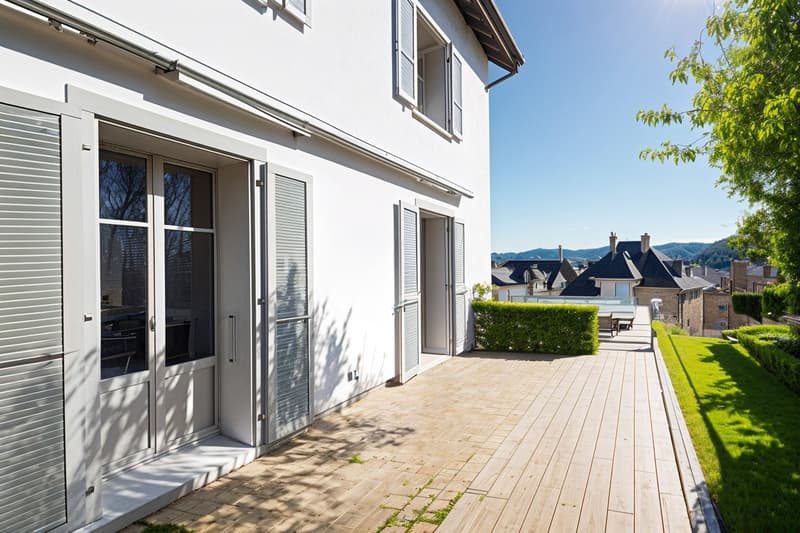 white exterior, wooden deck, hedges, large windows, balcony