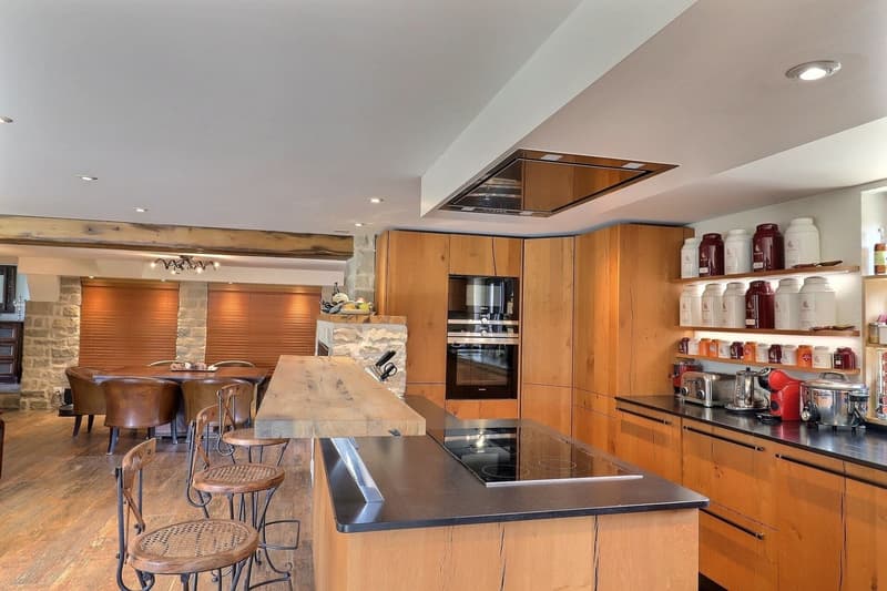 wood floor, wooden counters, induction hob, wooden cabinets, built-in oven, wine glasses