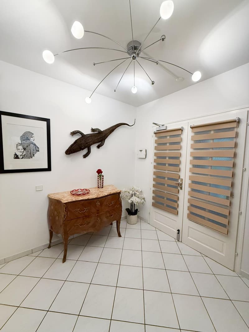 tiled floor, ceiling lamp, picture frame, wall decor, sideboard, flower vase, closed doors, white curtain