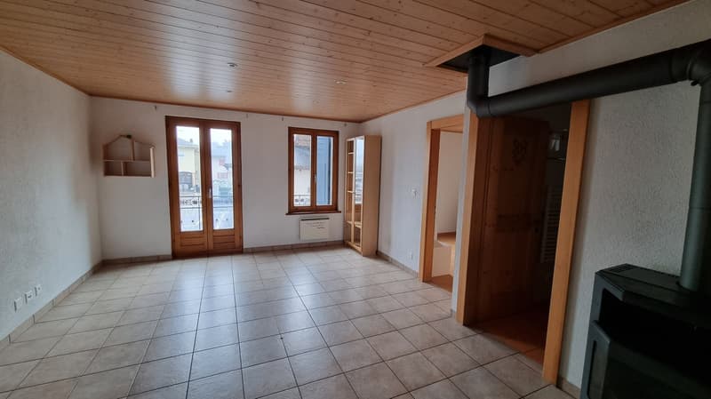 tiled floor, wooden ceiling, fireplace, two glass doors leading to outdoors, white walls, cabinets, radiator