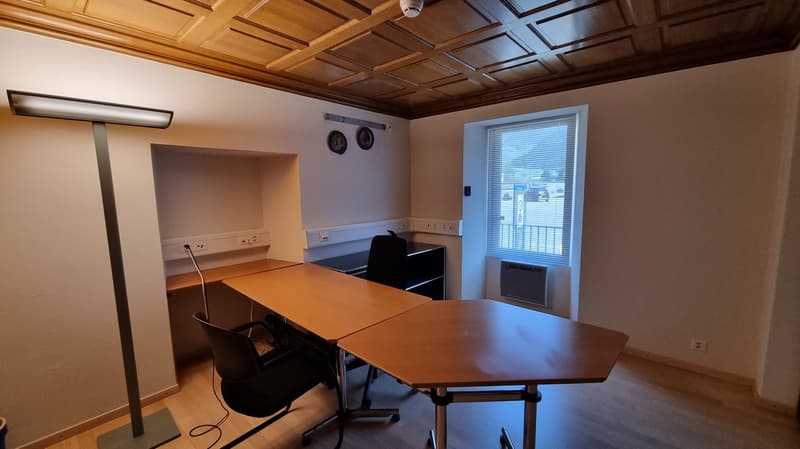 Office room with desks, chairs, lamp, outlet, window with blinds, wall mounted plates, ceiling lamp
