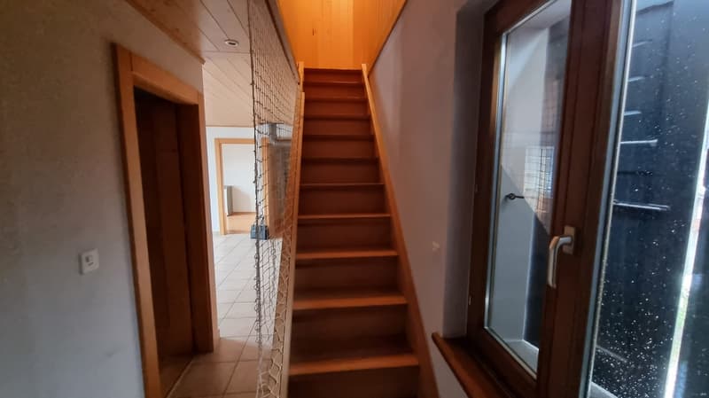 wooden stairs, white tiled floor, wooden door, power outlet, window
