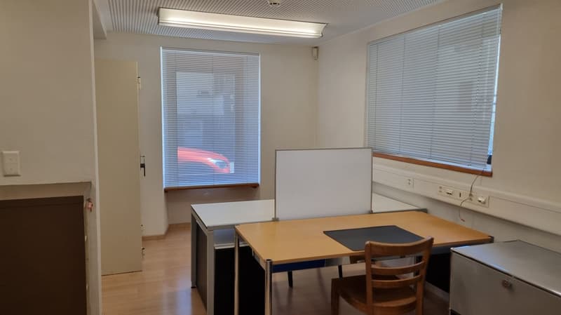an empty room with tables, chairs, and white walls