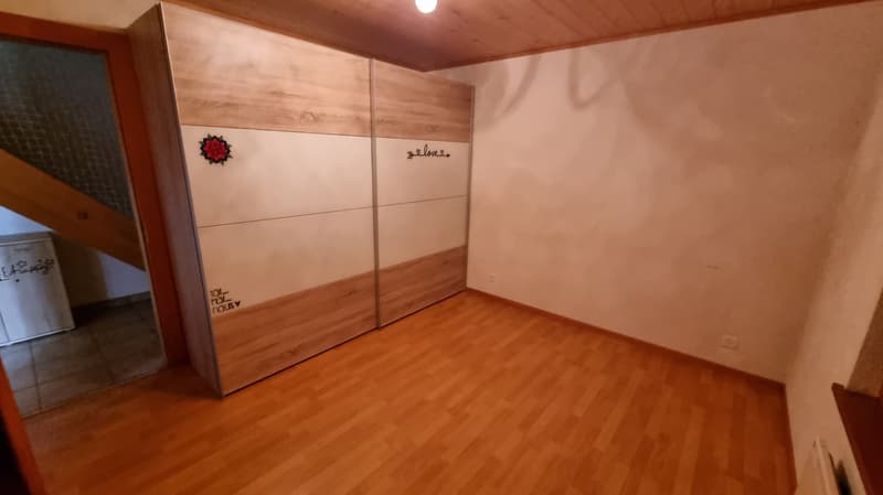 Empty room with large wardrobes, wooden flooring, white walls, power outlets, light switch, door to another room