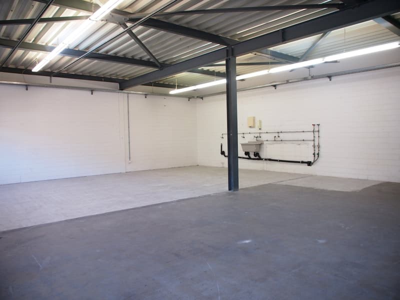 Large open space, white walls, metallic ceiling, concrete floor, metal column, plumbing fixtures