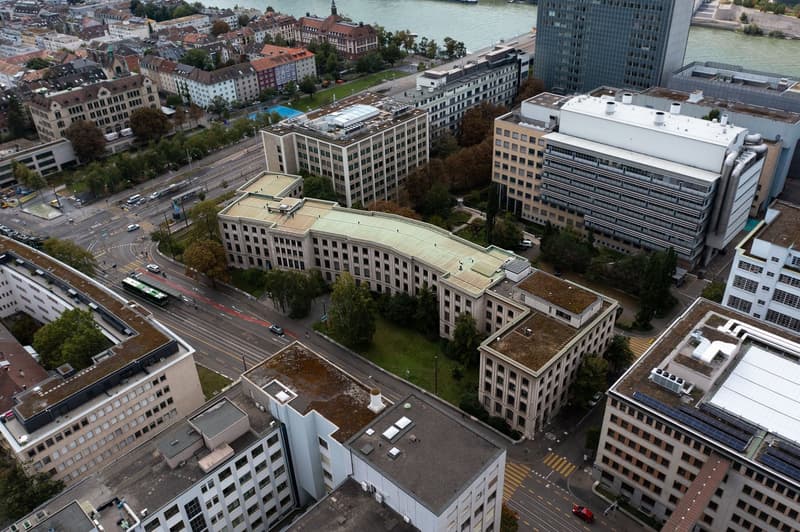 Urban area with multiple buildings, roads, trees, and a view of a river