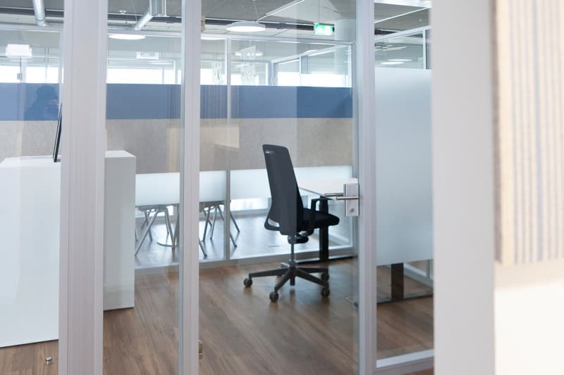 glass walls, black swivel chair, desk, wooden floor, dividers