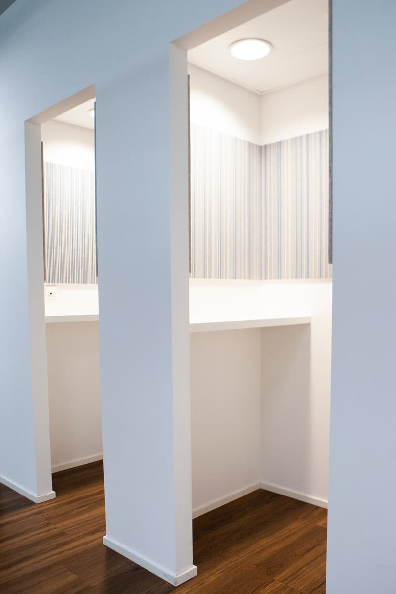 Empty room with white walls and wooden floors, a white shelf on the right side