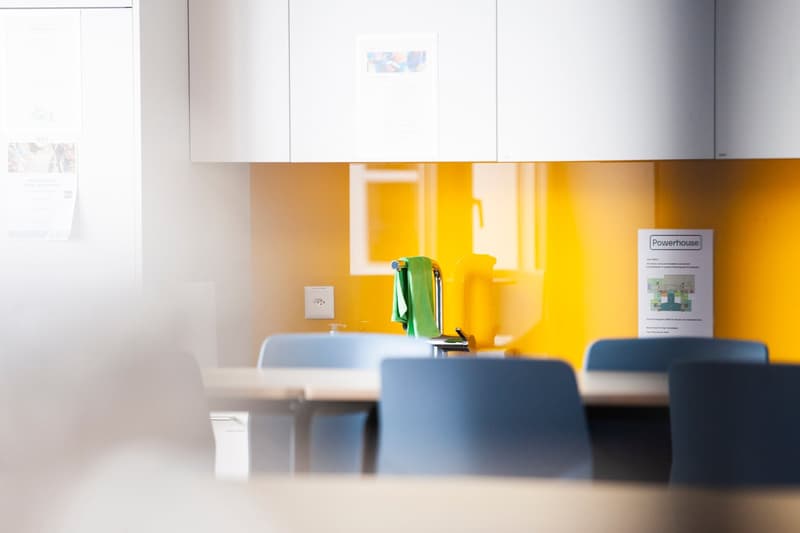 a table, chairs, yellow wall, power outlet, paper, green towel