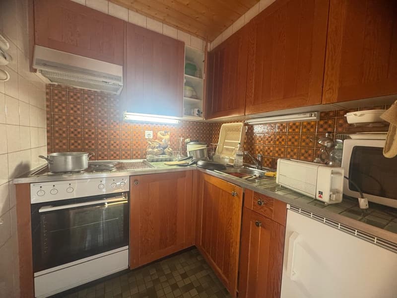 wooden cabinets, tiled floor, tiled backsplash, gas stove, oven, sink, microwave, toaster, dishwasher