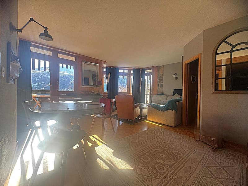 living room with wooden floor, large windows, wooden furniture, rug, and a view of the mountains