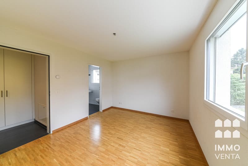 / an empty room with hardwood floors and a large window