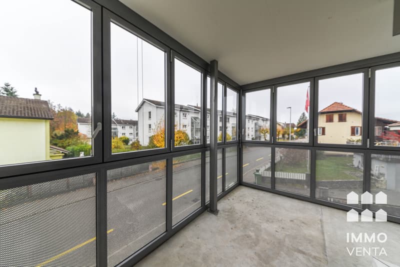 / a room with large windows and a balcony