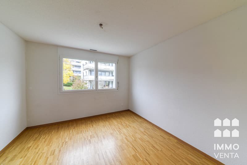 / an empty room with white walls and a large window
