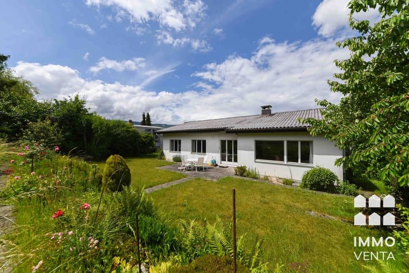 / a large white house with a garden and lawn in the countryside