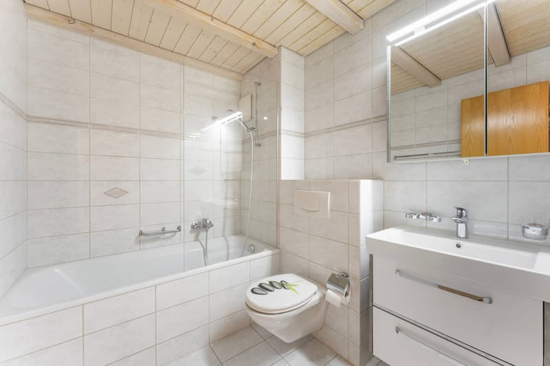 white tiles, bathtub, shower, toilet, sink, mirror, wooden cabinet