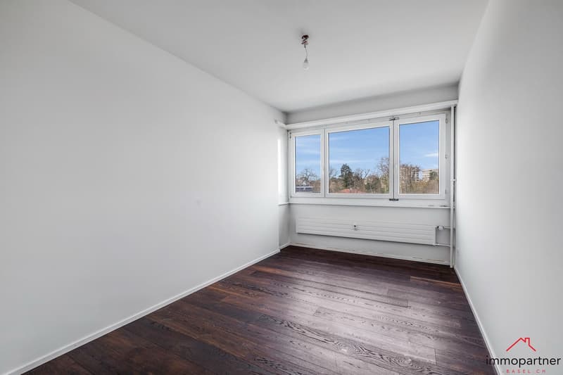empty room, white walls, wooden floor, large window, white radiator