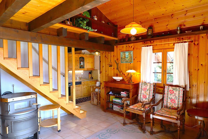 fireplace, wooden paneling, dining table, chairs, table lamp, kitchen