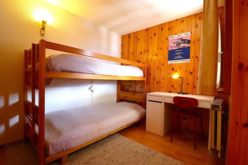 wooden bunk bed, desk, red chair, radiator