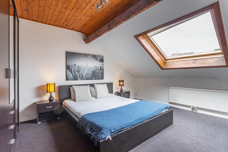 bedroom with bed, nightstands, lamps, wardrobe, painting, radiator, window