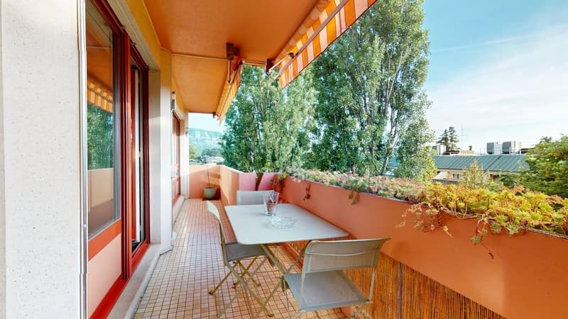 a balcony with tiled floor, white table and chairs, wooden railings, and awning. Potted plants on the balcony and on the wall