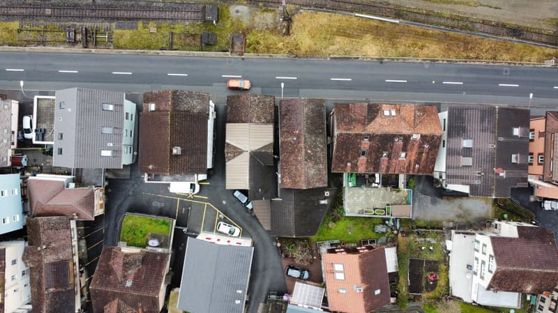 aerial view of terraced houses with several parked cars