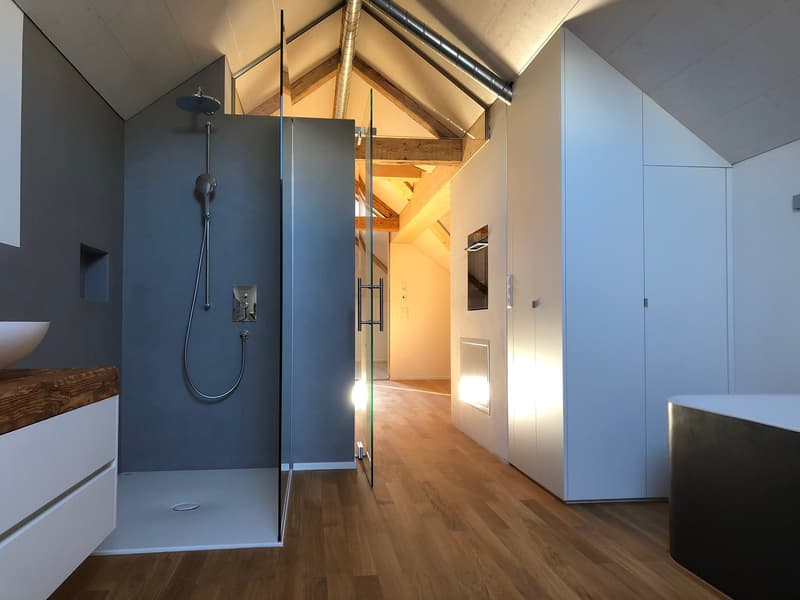 large shower, bathtub, wooden floor, ceiling with wooden beams