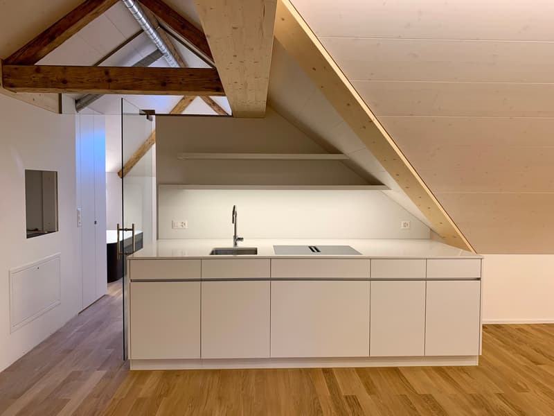 modern kitchen, white cabinetry, stainless steel sink, wooden flooring, exposed beams, power outlets, small window