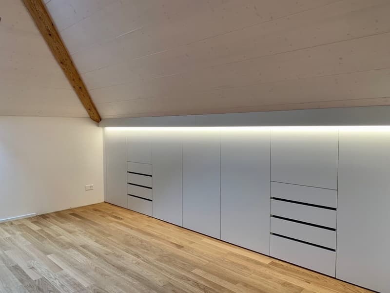 Wooden flooring, built-in storage units, white ceiling, exposed wooden beam, power outlet