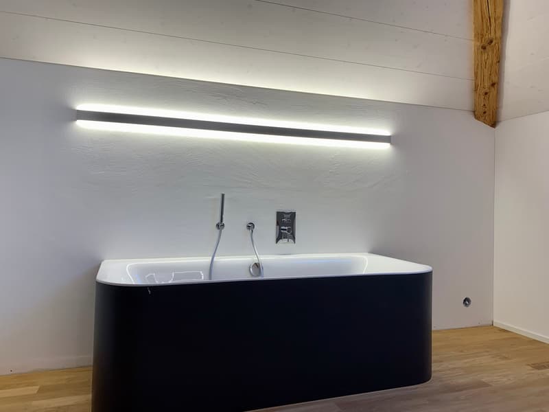 modern bathroom, free-standing bathtub, wall-mounted faucet, wooden beams, wall-mounted light