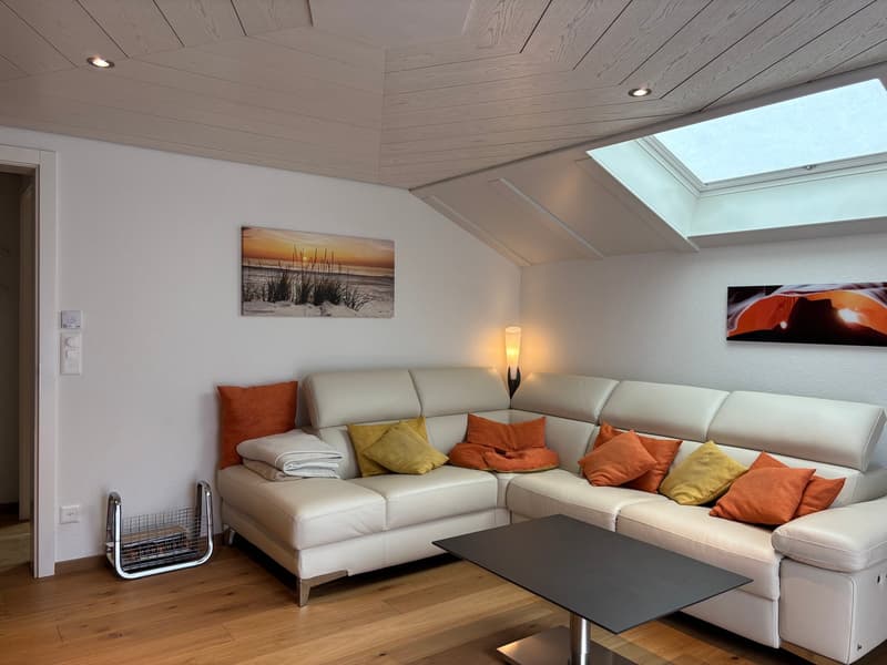 L-shaped white leather sofa, coffee table, wall art, wooden floor, skylight