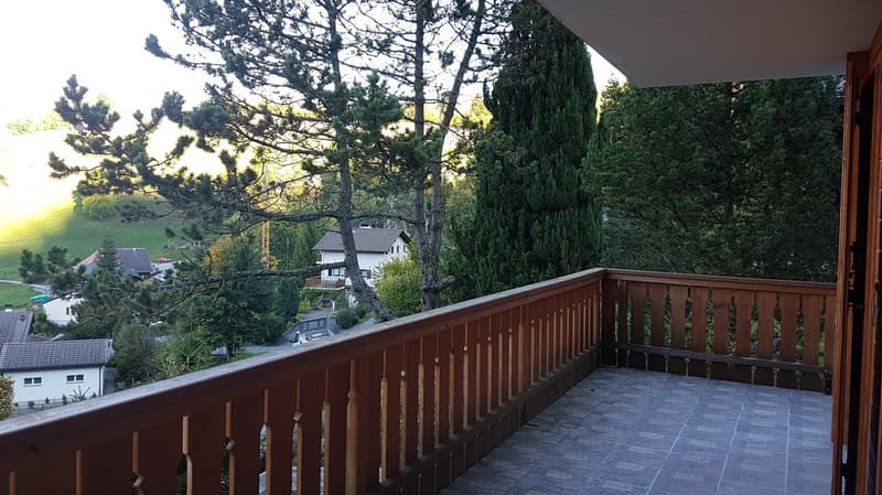 wooden railing, view of trees and surrounding houses