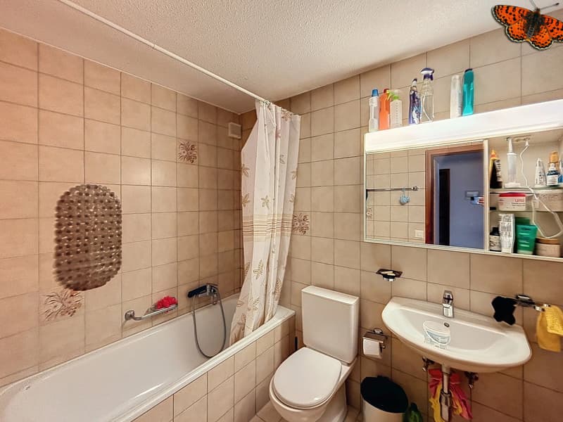 / a bathroom with a sink, toilet, tub and mirror on the wall