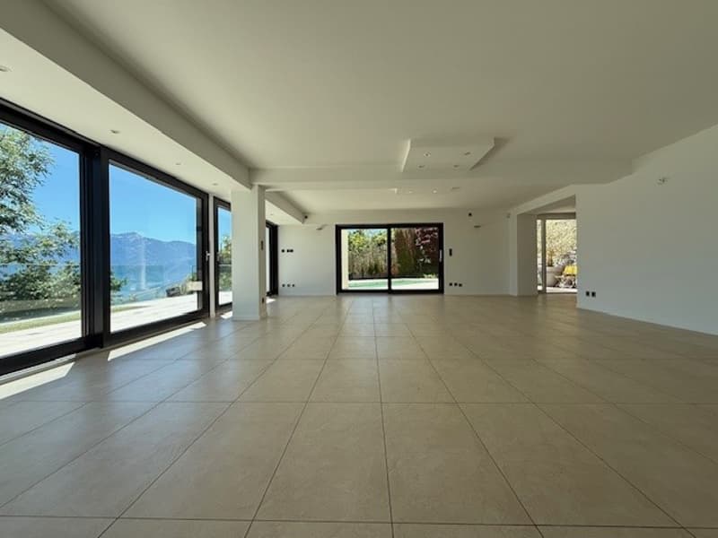large room, large windows, tiled floor, white walls, view of the mountains